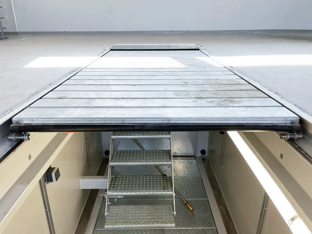 Moderne Werkstattgrube mit rollbarer Grubenabdeckung und integrierter Beleuchtung. Die Aufnahme zeigt eine platzsparende und sichere Abdeckungslösung für LKW-Werkstätten zur Abdeckung nicht genutzter Wartungsgruben.