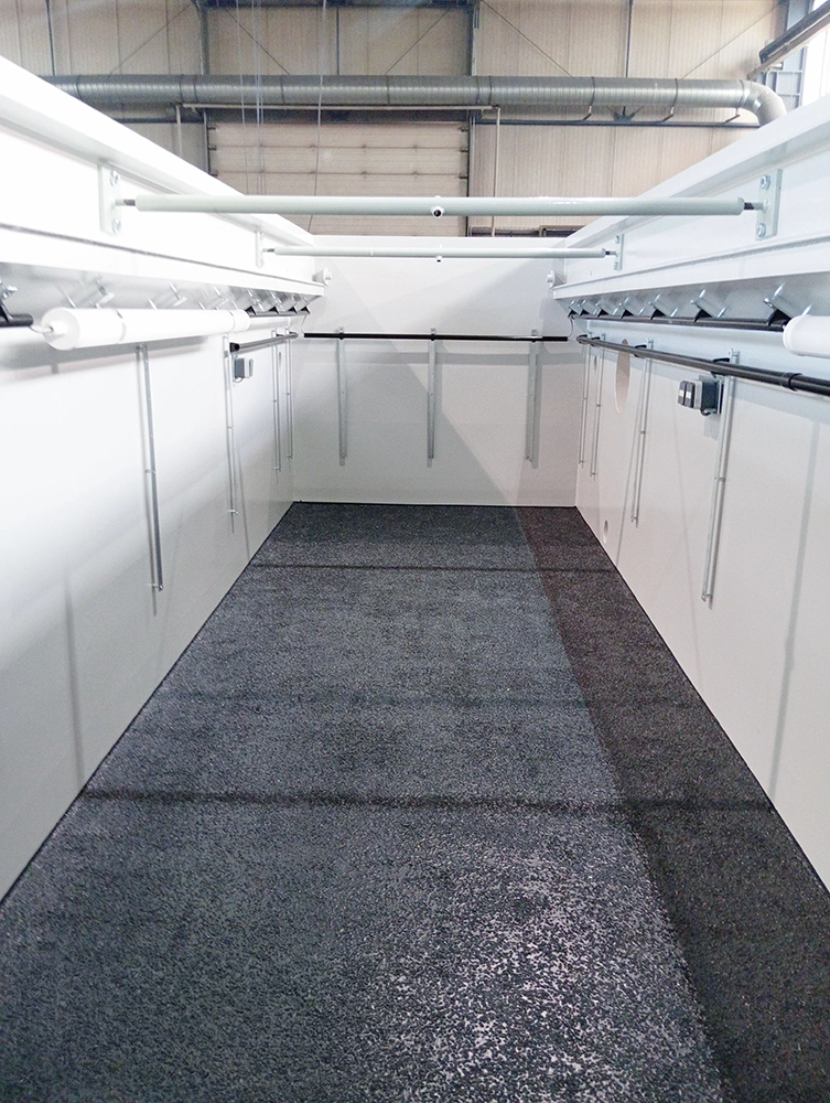 Moderne Montagegrube mit strapazierfähigem, beschichtetem Bodenbelag und integrierter Versorgungstechnik. Die Aufnahme zeigt eine pflegeleichte und langlebige Bodenlösung für den professionellen Einsatz in LKW-Werkstätten.