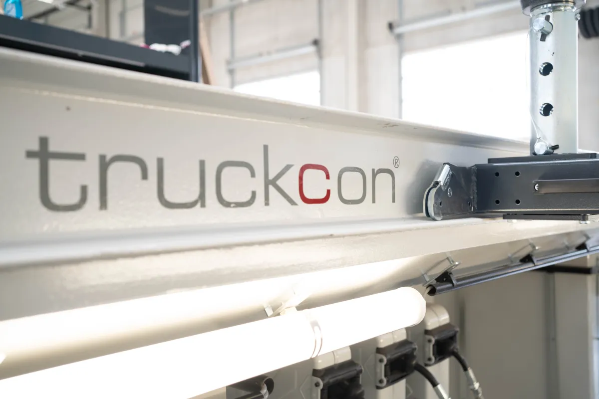 Detailaufnahme der integrierten Beleuchtungs- und Versorgungstechnik einer truckcon Werkstattgrube. Die Kombination aus LED-Beleuchtung, Stromversorgung und modularen Komponenten sorgt für sichere und effiziente Arbeitsbedingungen bei Wartungsarbeiten an Nutzfahrzeugen.