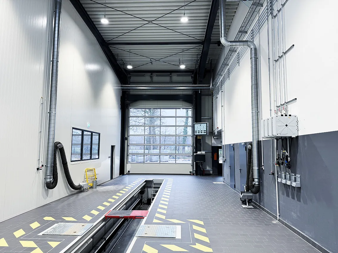 Moderne LKW-Werkstatt mit integriertem Rollenbremsprüfstand und Werkstattgrube für Nutzfahrzeuge. Die Aufnahme zeigt den Prüfbereich für professionelle Bremsentests, Wartungsarbeiten und sicherheitsrelevante Fahrzeugprüfungen.