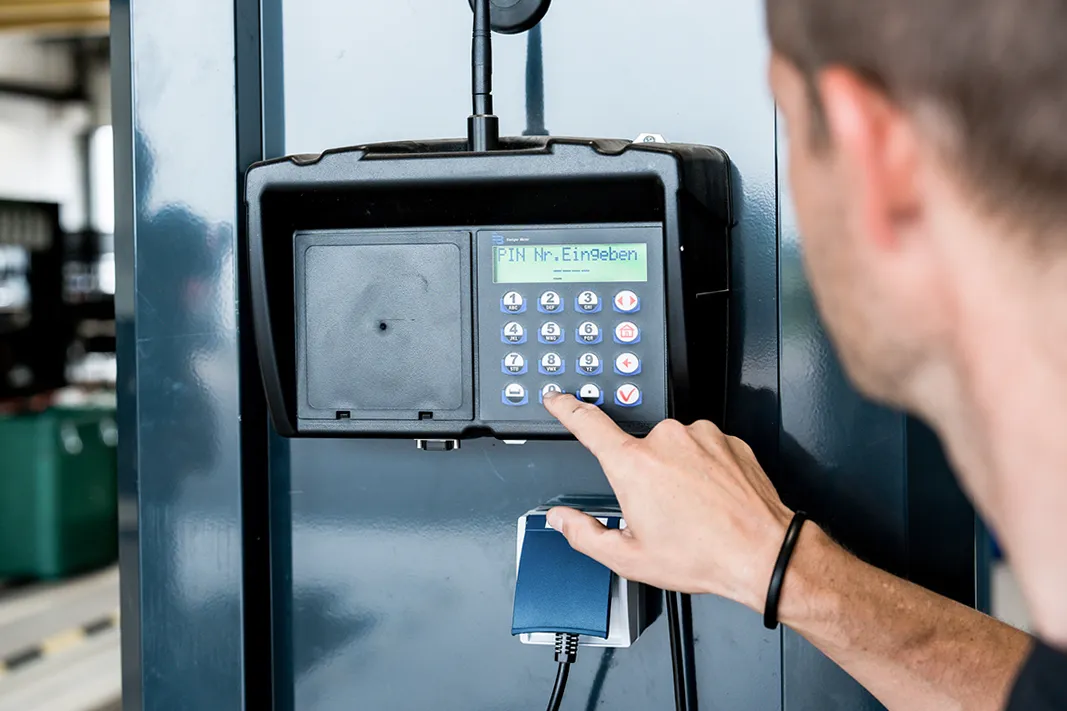 Nahaufnahme eines Bedien- und Steuerungssystems für Werkstatttechnik in einer Nutzfahrzeugwerkstatt. Die Aufnahme zeigt die digitale Steuerung eines truckcon Systems zur Bedienung technischer Komponenten innerhalb der Werkstattgrube.